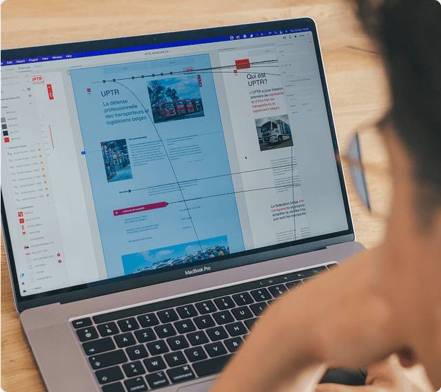 Prototype Person reviewing a website design on a MacBook Pro, featuring text and images in a design software interface.